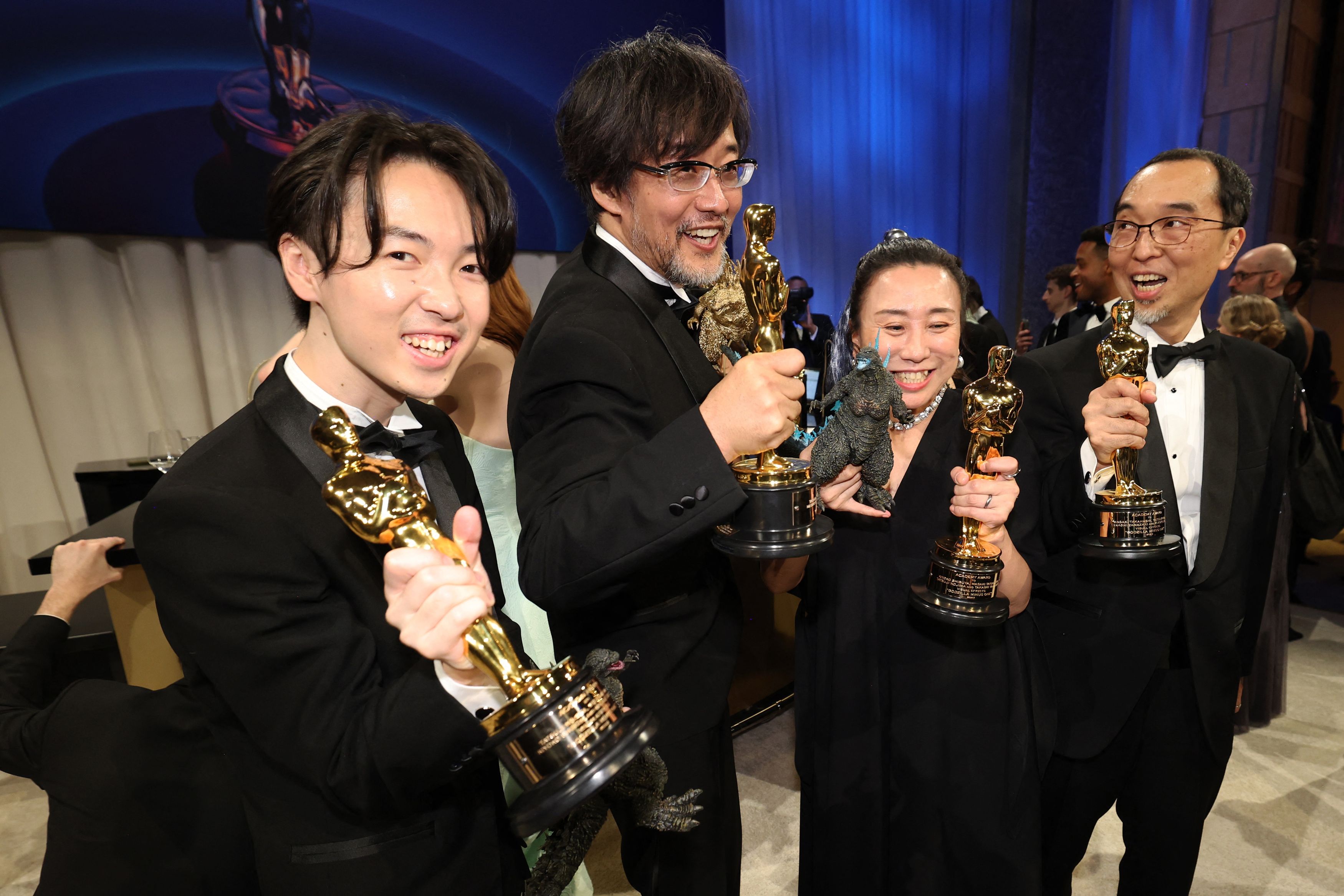 第96回アカデミー賞で「ゴジラ-1.0」が視覚効果賞を受賞し、オスカー像とゴジラを手にしてポーズをとる山崎貴監督（左から２人目）ら白組スタッフ