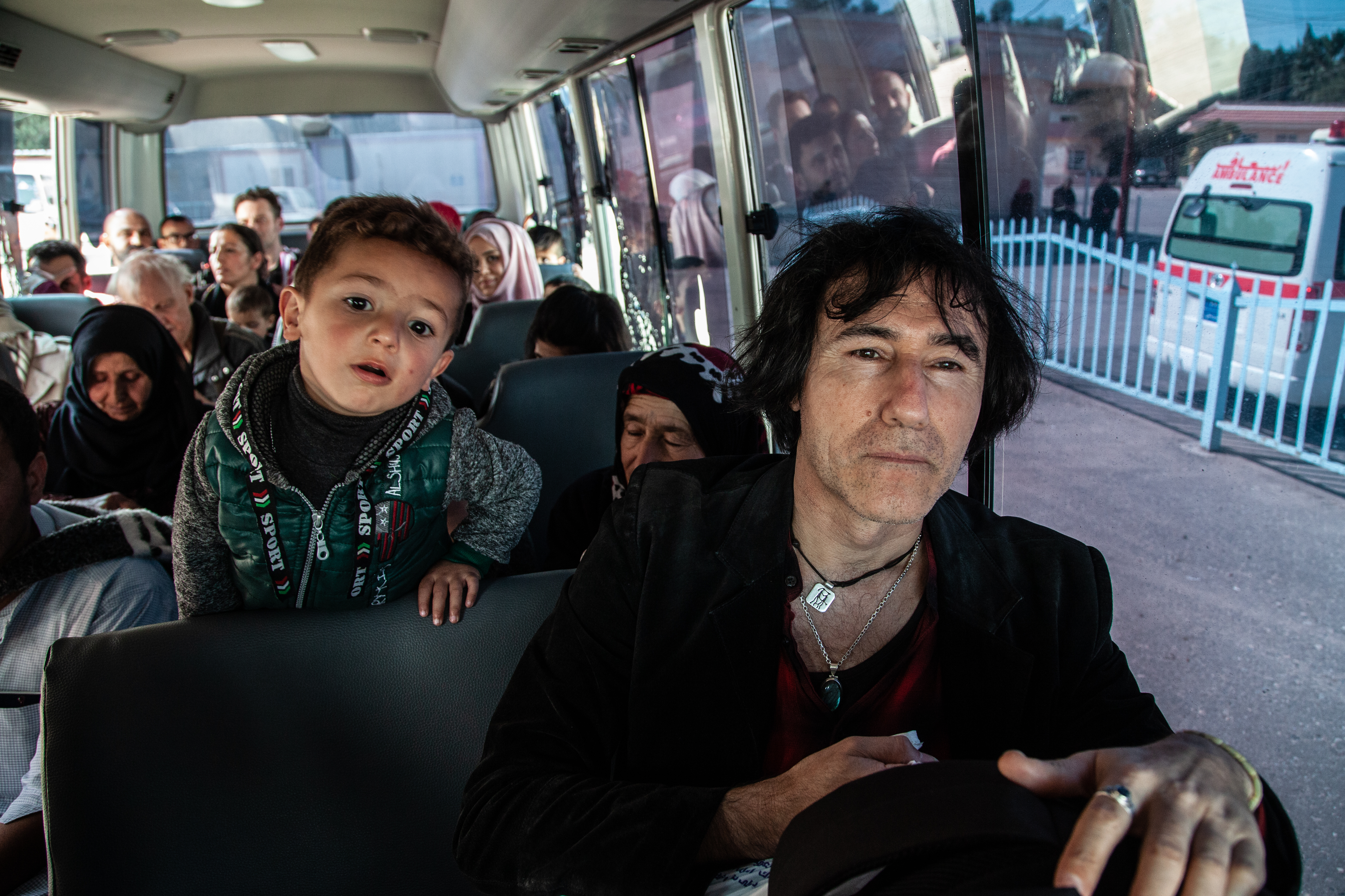 イラクからシリア北部へ国境を越えるシリア人家族らと公共バスでのパトリシオ。「“敵”の子どもたち」