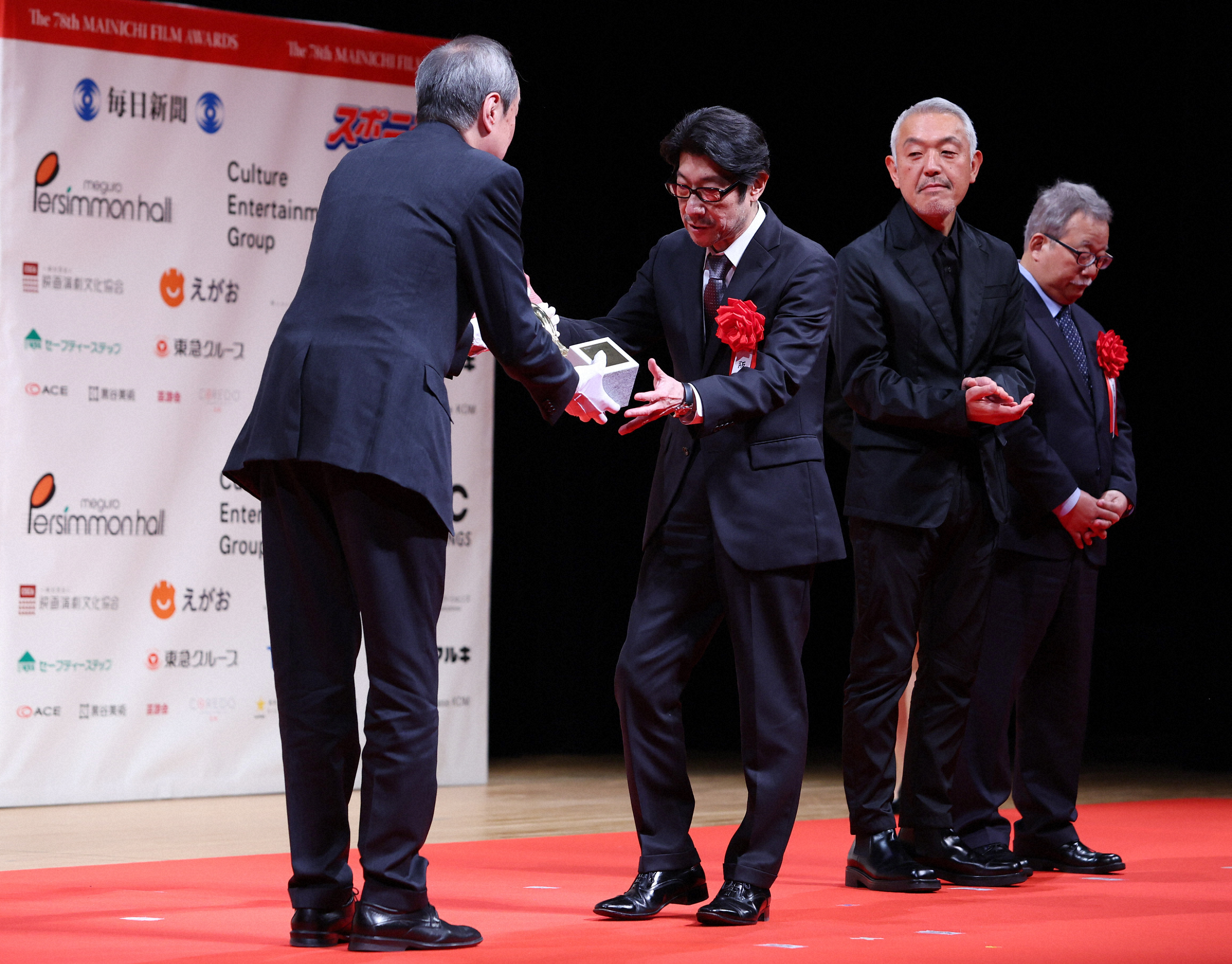 第78回毎日映コン・日本映画大賞を受賞し、トロフィーを受け取る阪本順治監督（右から３人目）とスタッフ