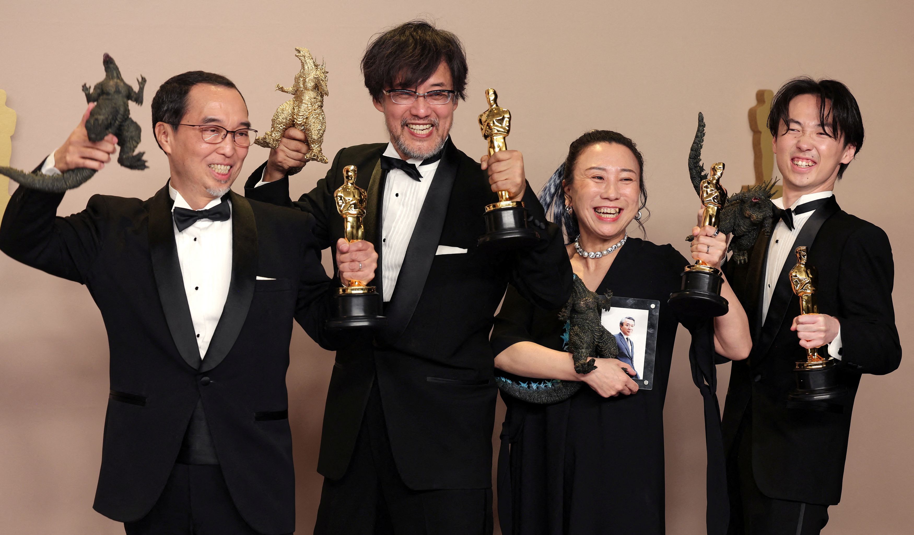 第96回アカデミー賞で「ゴジラ-1.0」が視覚効果賞を受賞し、オスカー像とゴジラを手にしてポーズをとる山崎貴監督（左から２人目）ら白組スタッフ＝ロイター