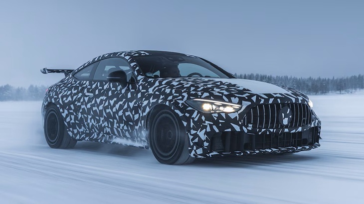 ユキヒョウ柄の様な外装のベンツが雪原を走行している様子を車体右前からとらえた様子