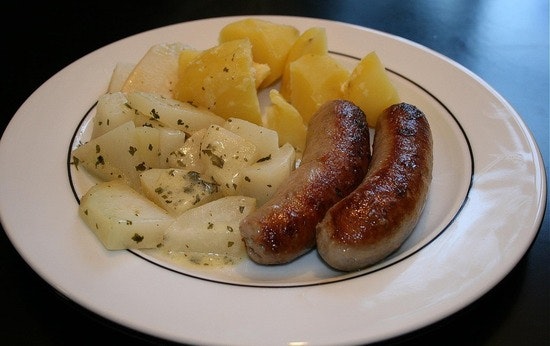 A plate of German sausages and potatoes.