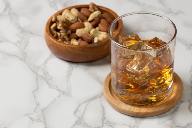 Whiskey on the rocks with nuts.