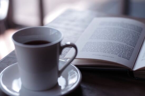 A cup of coffee with a book.