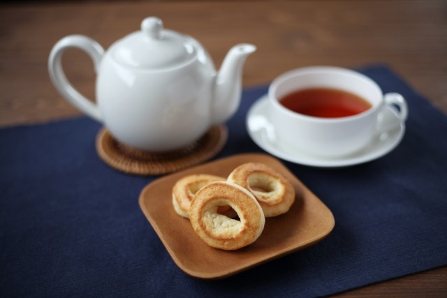 A pot of tea with some sweets