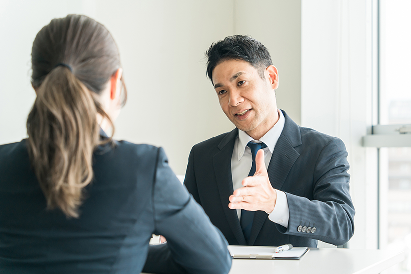 オフィスで左手を差し出して提案をする営業の男性