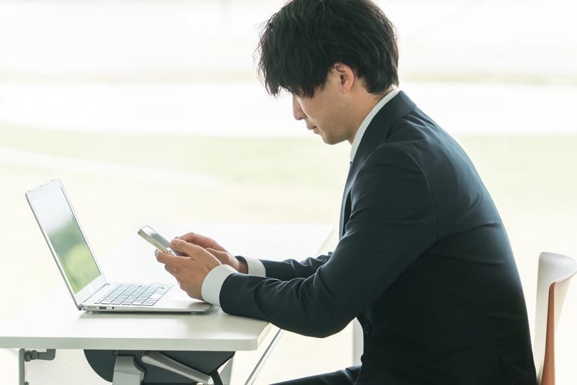 スマホを操作する男性の画像