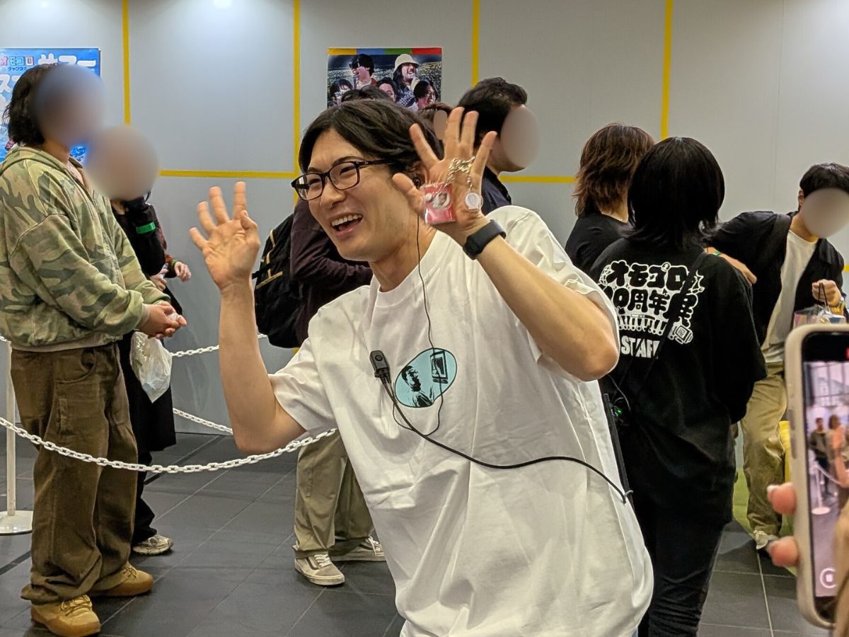 みくのしんさんが両手を広げて笑顔でファンサービスをしている。