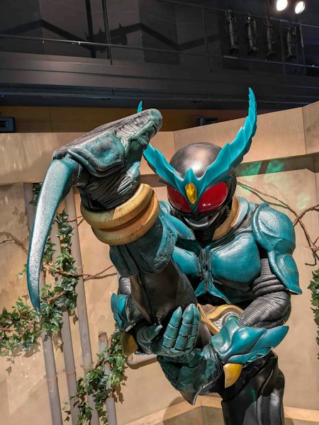 必殺技のギルスヒールクロウ(かかと落とし)をする仮面ライダーギルスのスーツ展示。
