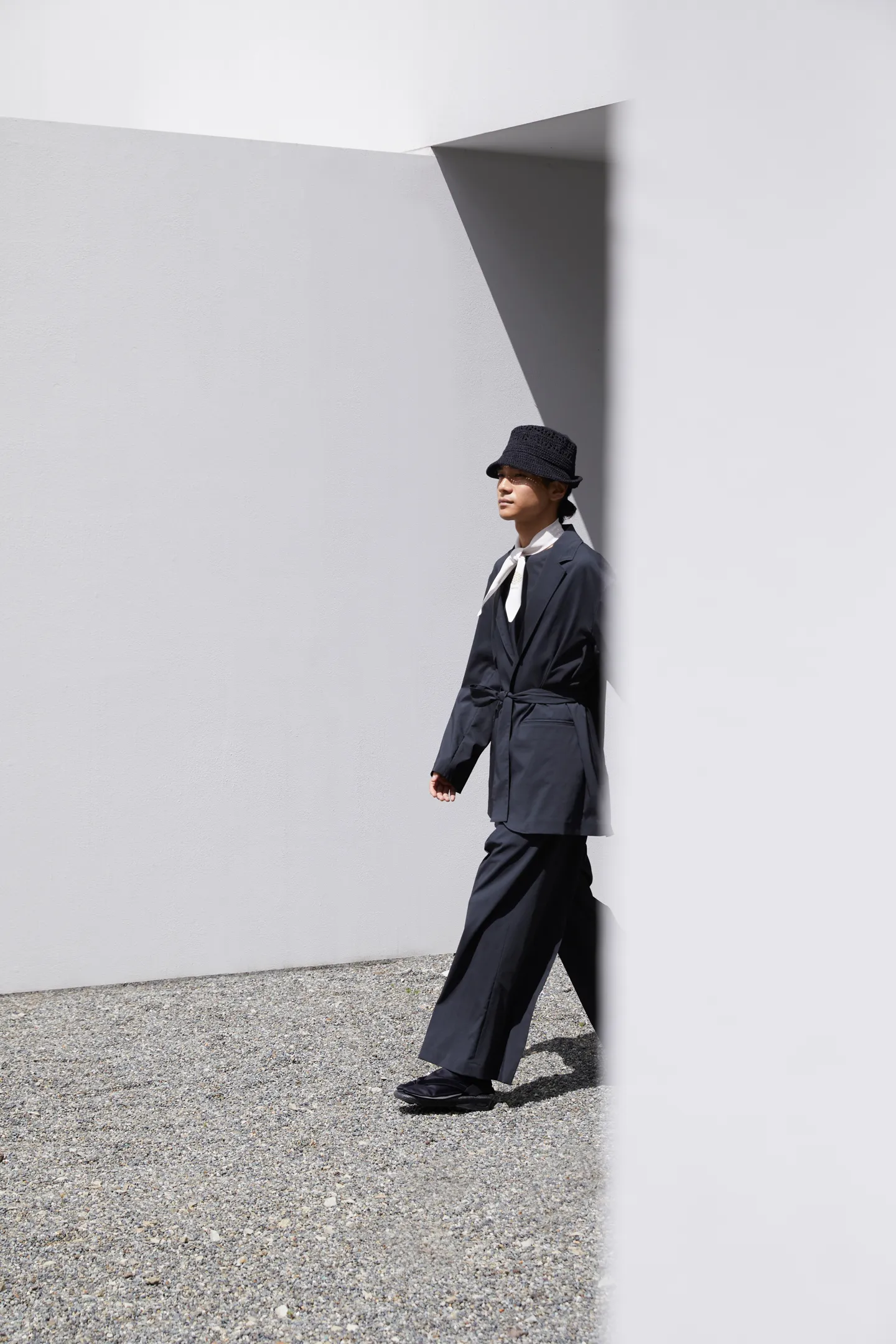 The same man as the previous photo walks out from behind a building.