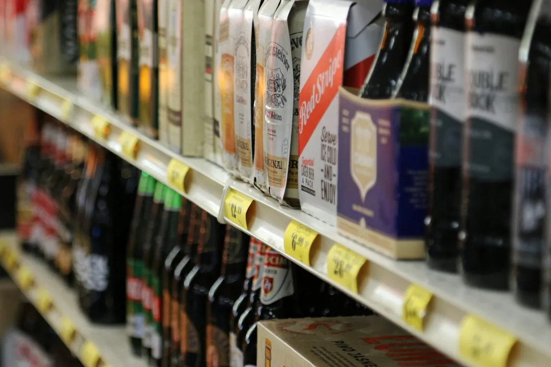 小売店の商品棚に並ぶ飲料と値札