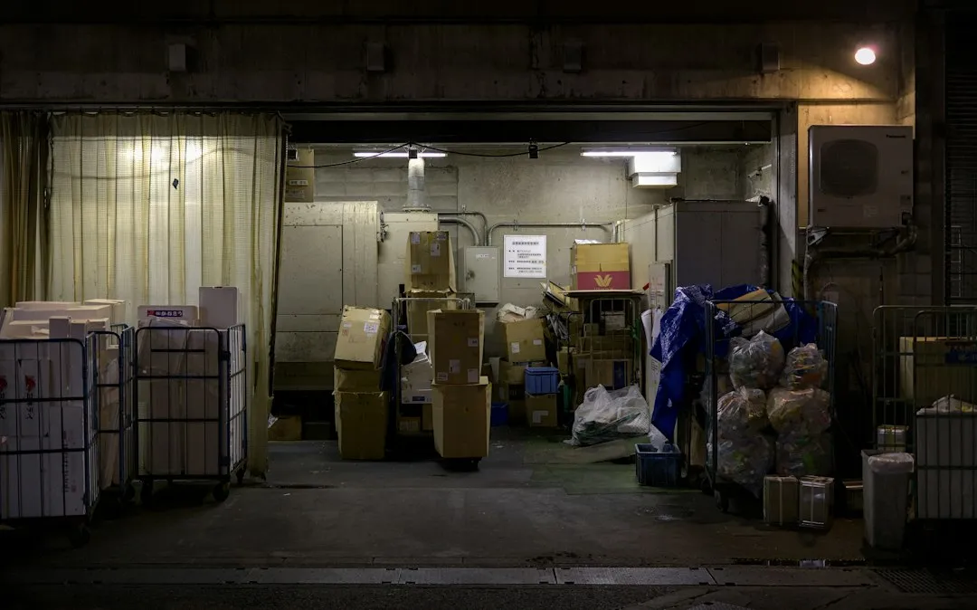 出荷を待つ段ボールが並ぶ倉庫。発注サイトの注文を在庫・出荷の管理へ渡すイメージ