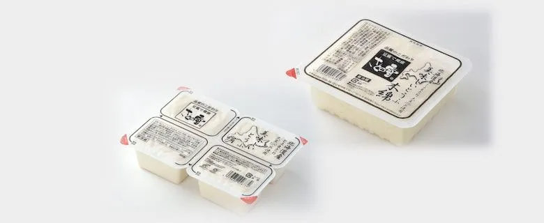 四国化工機の豆腐パック。AIが割れ・欠けを判定し、ロボットが不良品を取り除く