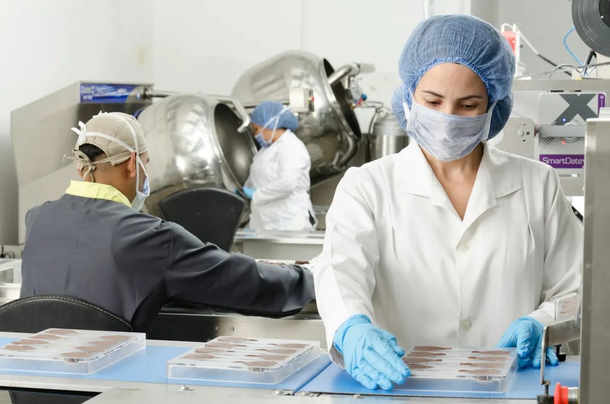 食品工場で衛生ウェアを着用した作業員。HACCP運用では温度・清掃・健康チェックの記録が毎日必要