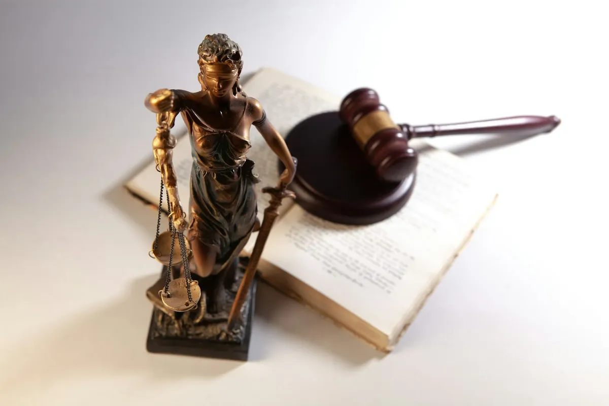 生成AIの声の権利に関する法務省の解釈指針を象徴する法律書と天秤のイメージ