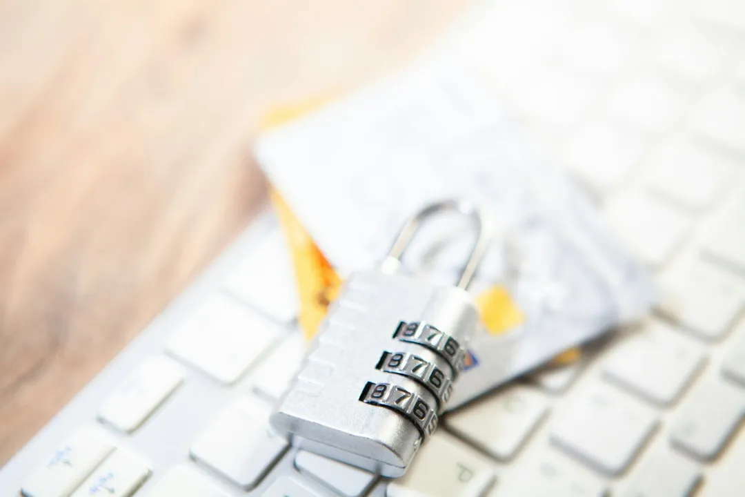 キーボードの上に置かれたクレジットカードと南京錠。ChatGPTのWeb決済と請求のイメージ