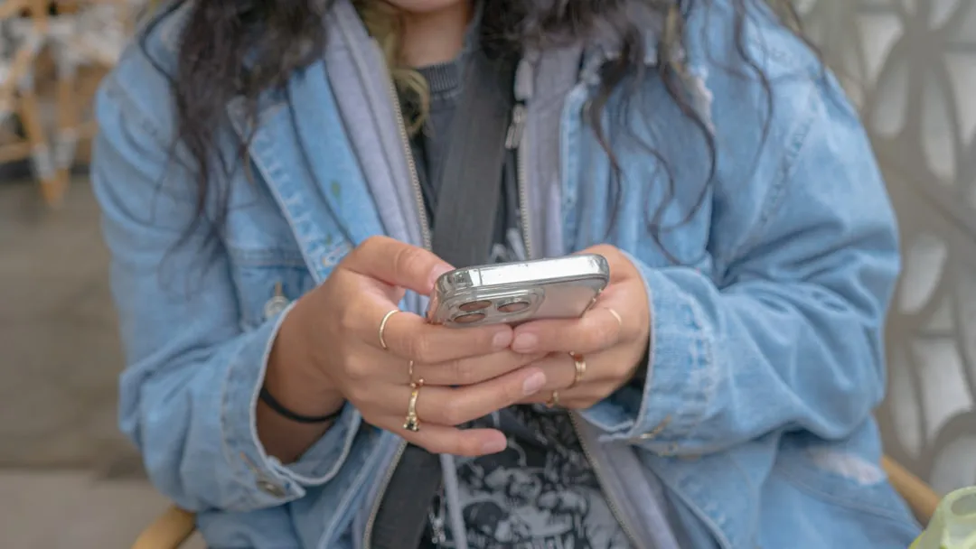 スマートフォンで通知を確認する女性のイメージ
