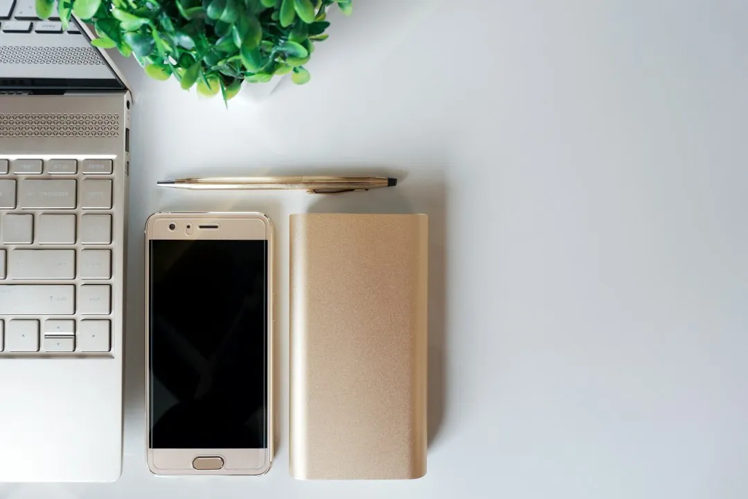 ノートパソコンとスマートフォンが置かれた仕事用デスク