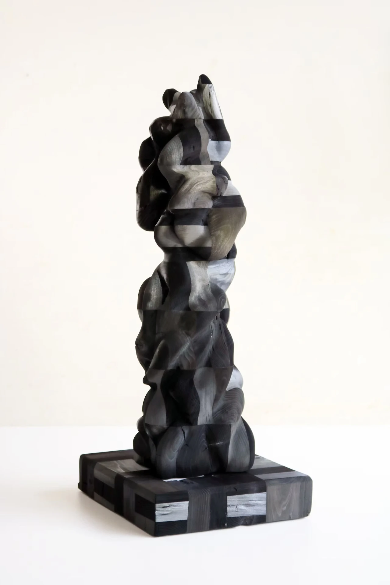 A sculpture of stacked, uneven forms rising from a rectangular base