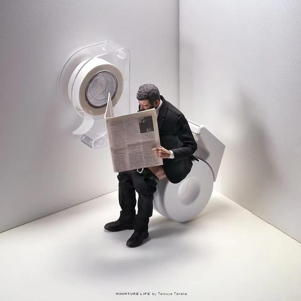 In the corner of a white room, a suited figure reads a newspaper while seated on a tape dispenser as if it were a toilet