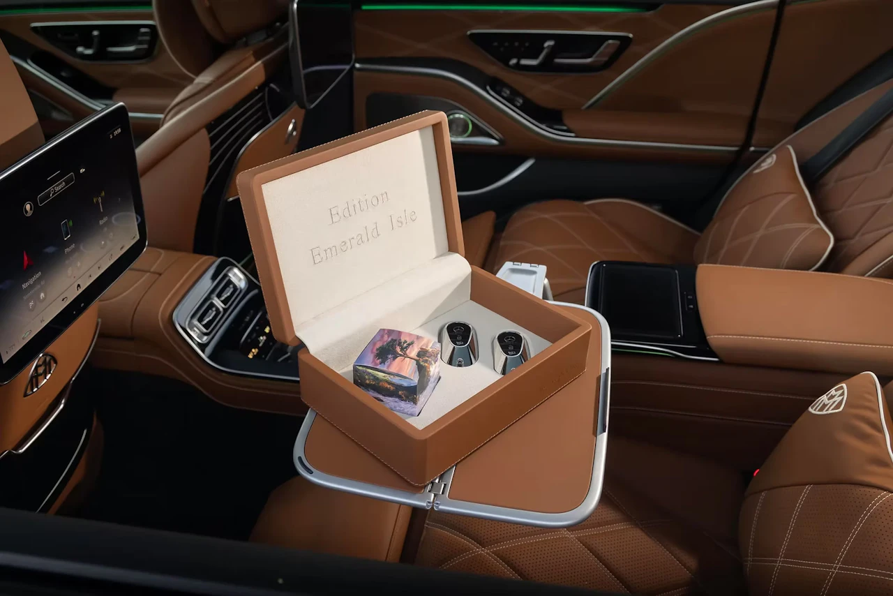 A rear cabin upholstered in tan leather, where an open leather case embossed “Edition Emerald Isle” sits on a fold-out table, holding a painted cube and two silver keys