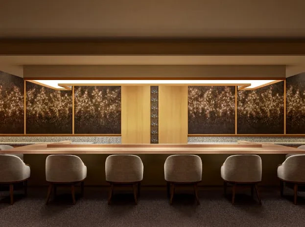 A dining counter of pale wood with a painted floral panel behind