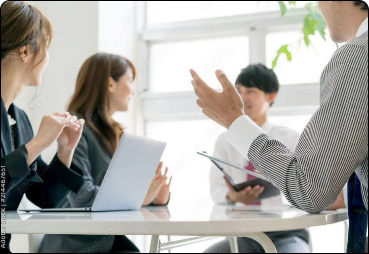 明るい会議室で打ち合わせをする人たち