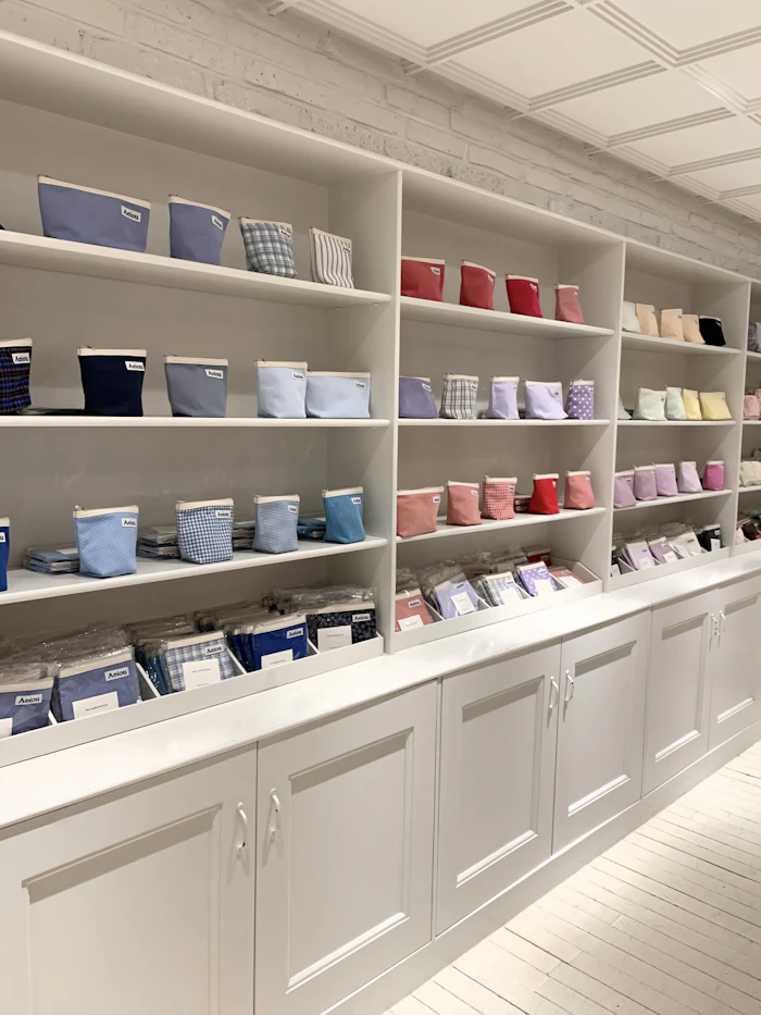 aeiou店内の広角ビュー。壁一面にパステル〜ビビッドのカラーポーチが並ぶ