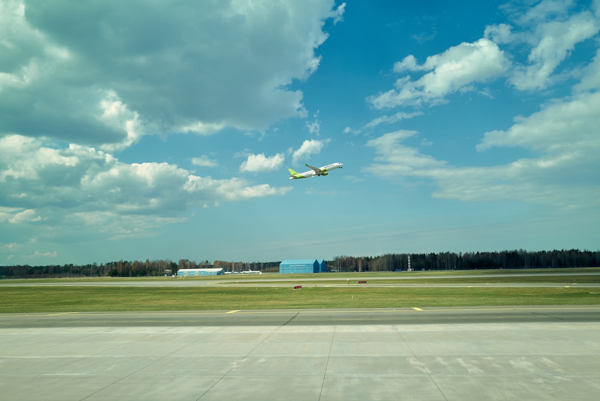 a plane flying through a cloudy blue sky