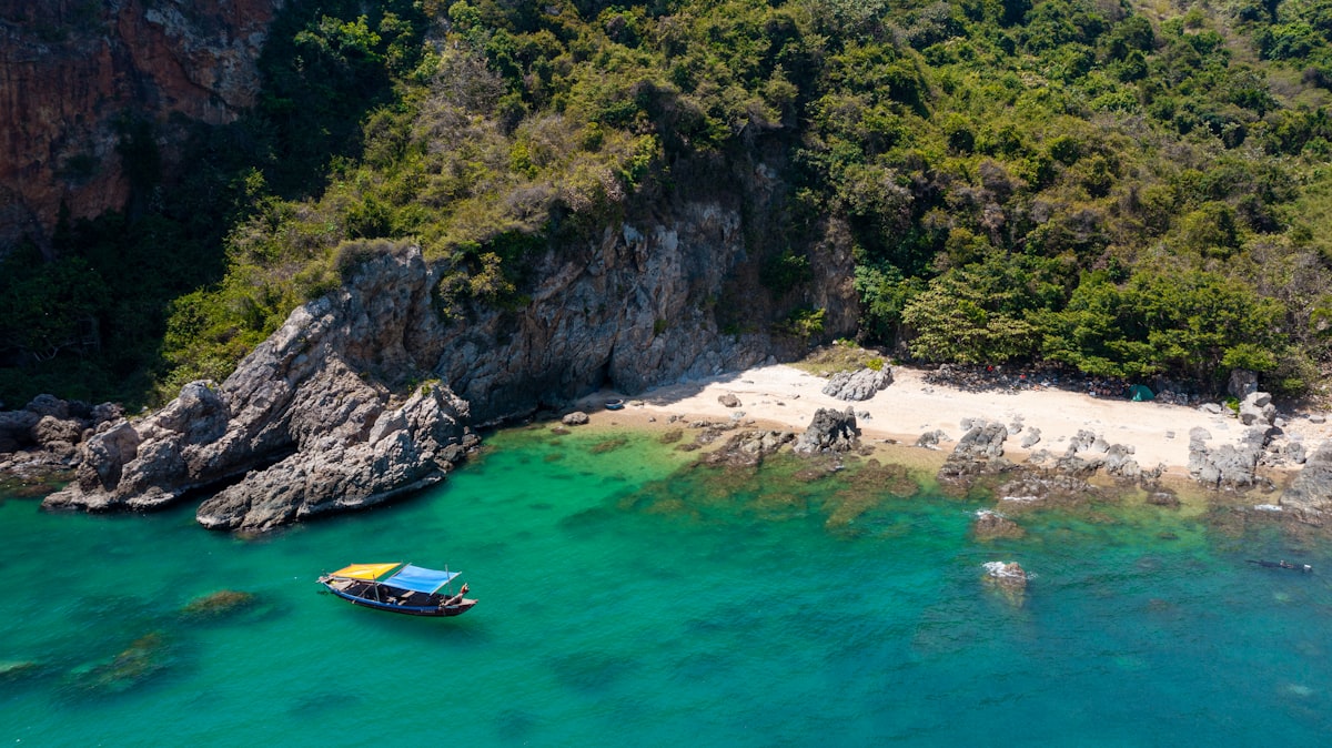 An aerial view of a beach with a boat in the water