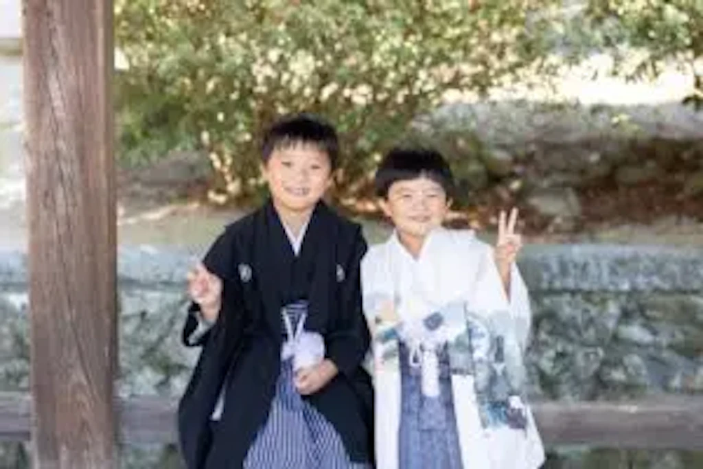 黒紋付きのお兄ちゃんと白水色の羽織袴の弟くんが並んでピースする七五三ショット