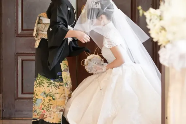 新婦の母がウェディングドレス姿の新婦のベールを下ろす瞬間