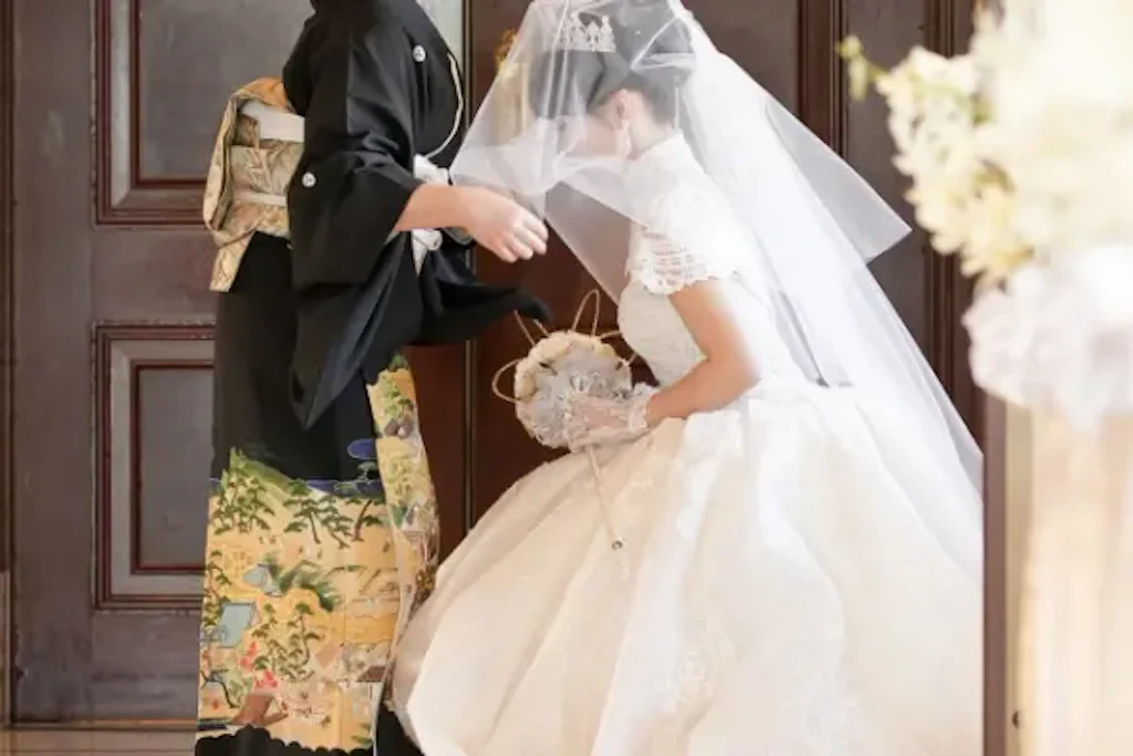 新婦の母がウェディングドレス姿の新婦のベールを下ろす瞬間