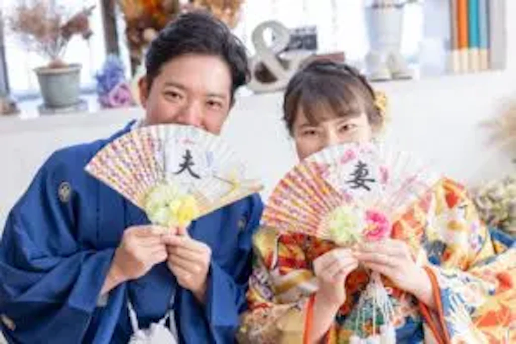 岡山のスタジオで扇子を手に微笑む新郎新婦様のフォトウェディングの記念撮影