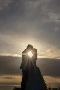 王子が岳の夕暮れ時、太陽を背にして寄り添う新郎新婦様のシルエット写真