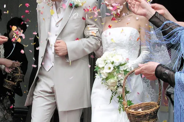 フラワーシャワーを浴びながらチャペルを笑顔で出る新郎と新婦