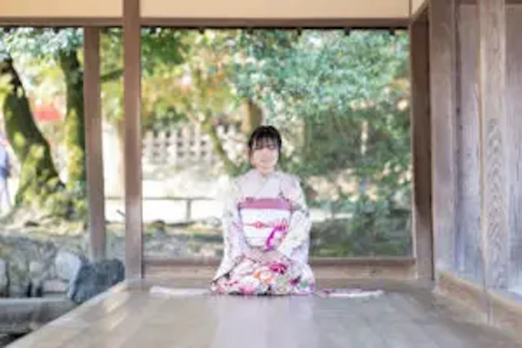 岡山後楽園の縁側に腰を下ろし、正座の姿勢で佇む成人式の前撮り撮影中の振袖姿のお嬢様