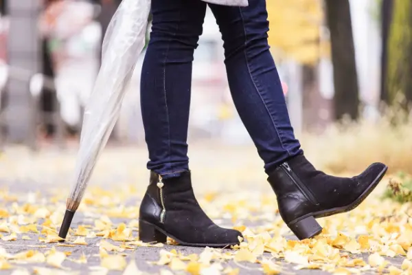 デニムパンツと黒いブーツを履いた足元