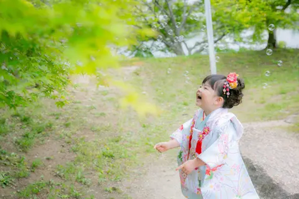吉備津彦神社の自然を見上げて気持ちよさそうにする七五三の女の子