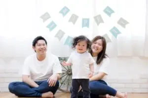 岡山市内のスタジオで、パパとママに笑顔で挟まれながら両手を広げて喜ぶ1歳の男の子