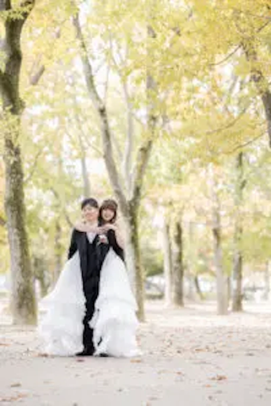 紅葉の並木道で手を取り合い正面を向く新郎新婦様の記念写真