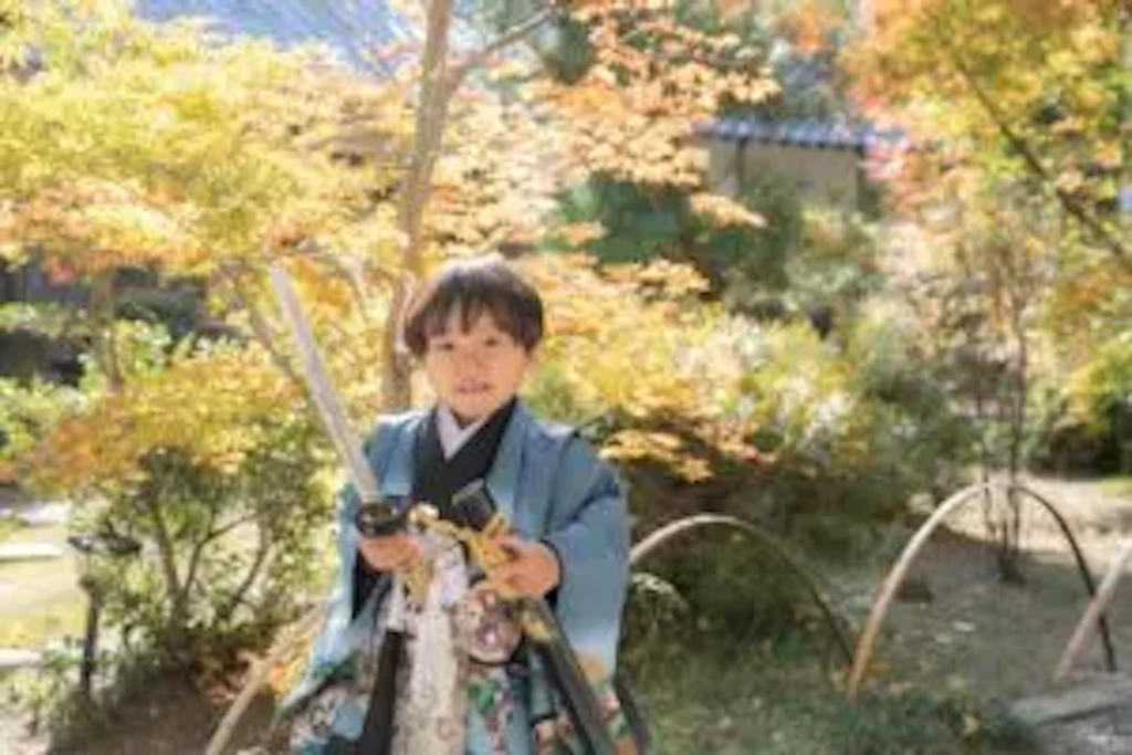 境内近くの秋の紅葉を背景に、吉備津彦神社で羽織袴姿を見せてくれる七五三の男の子