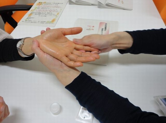 実際に患者さんの前で保湿剤を塗って見せている様子