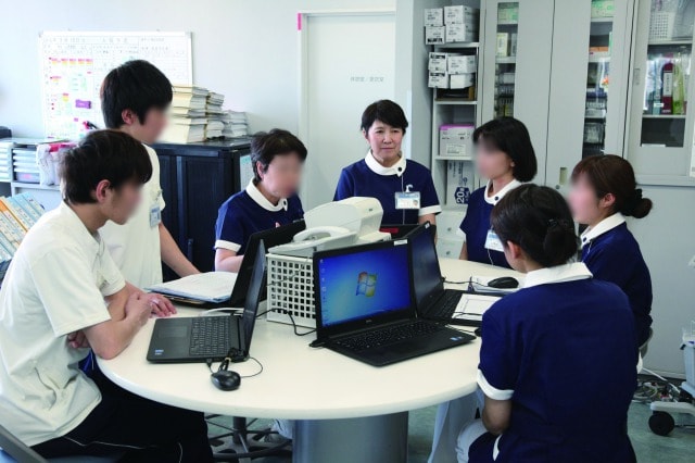 ナースステーションにて看護師同士が意見を交わし、話し合っている写真