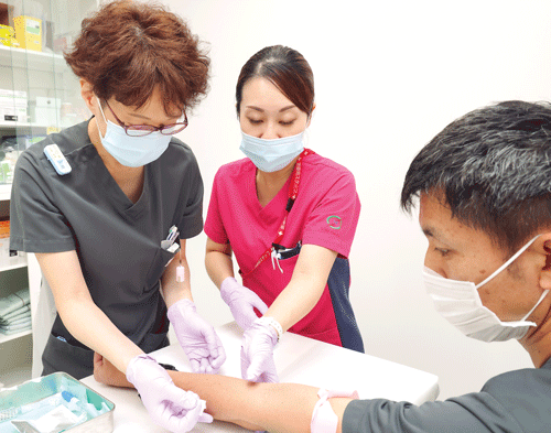 患者さんの腕の向きや支え方など、平野さんは実施のコツも伝えていく