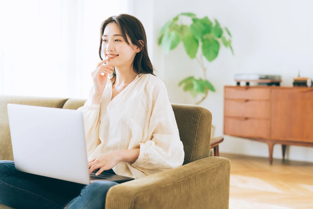 PCを開く笑顔の女性