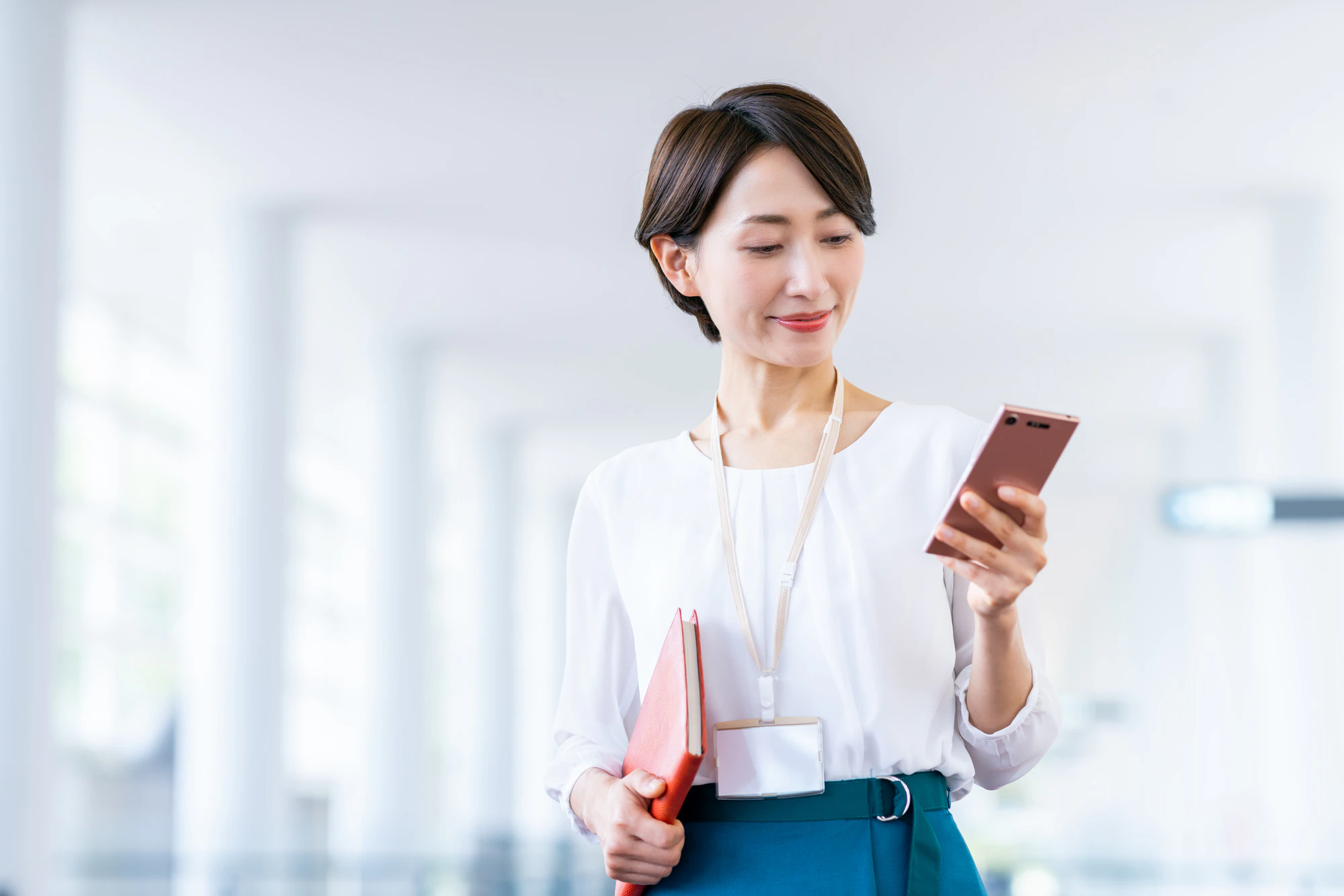 通路でスマホを見つめる女性