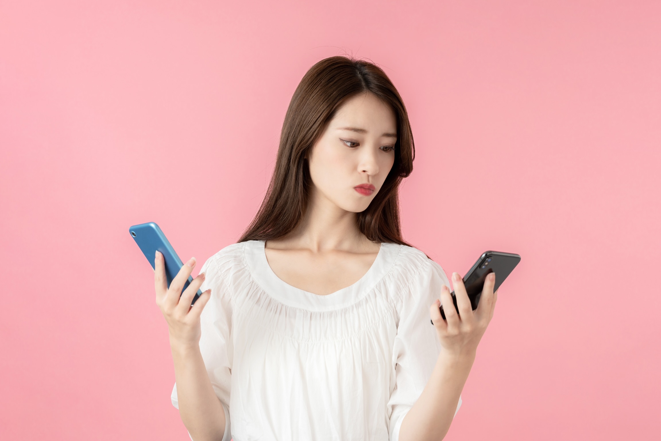スマホを触り比べる女性