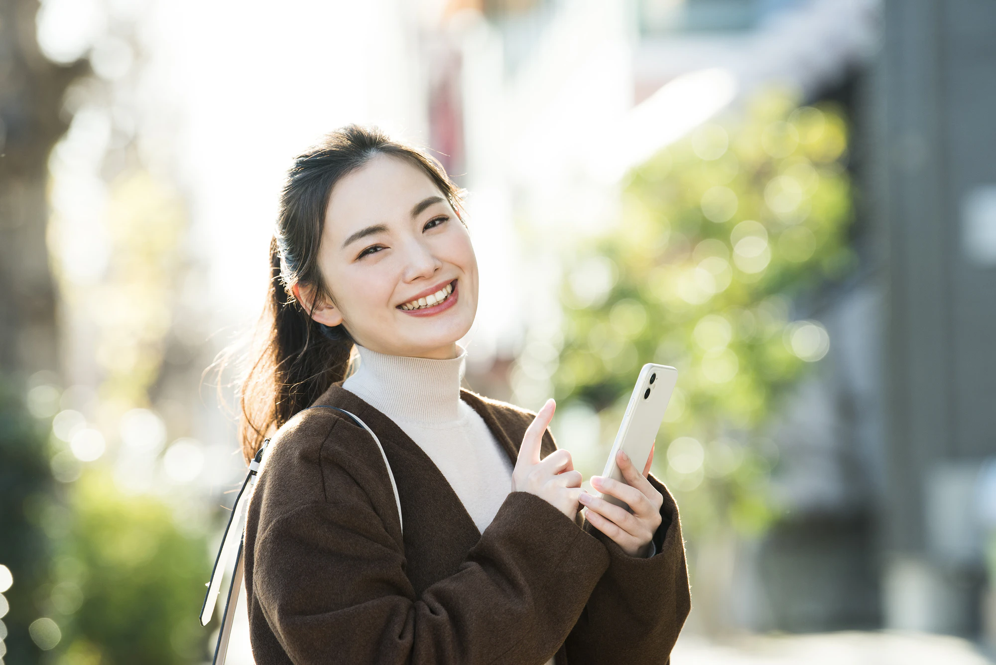 笑顔でスマホを持つ女性