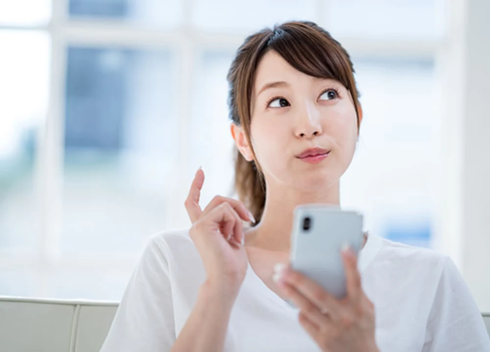 スマホを持って考える女性